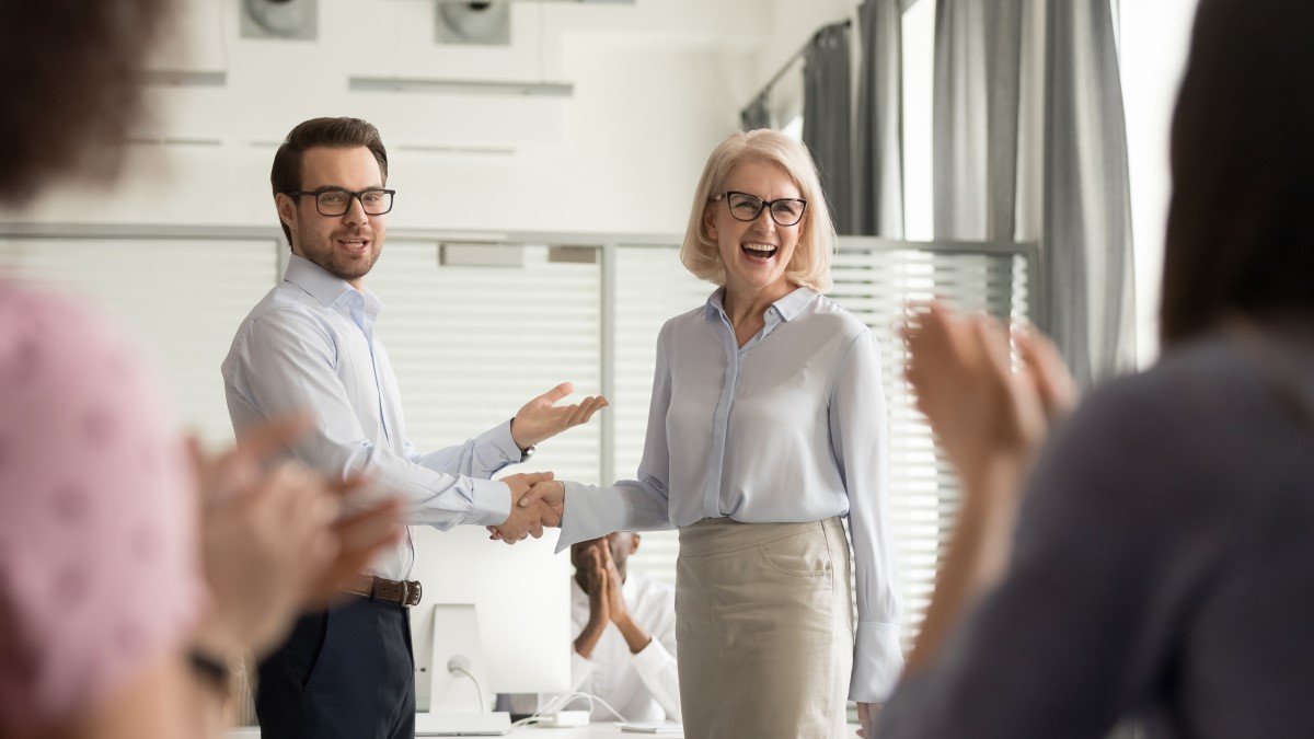 Boss shakes hand of employee that's done a great job