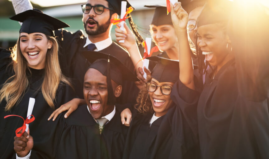 A group of graduates in graduation gowns celebrate their success.
