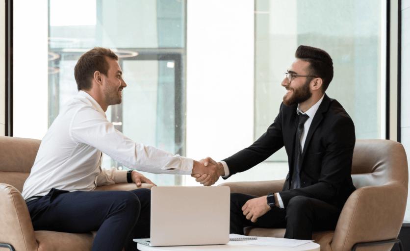 An employee shakes hands with his interviewer at the conclusion of an exit survey and interview