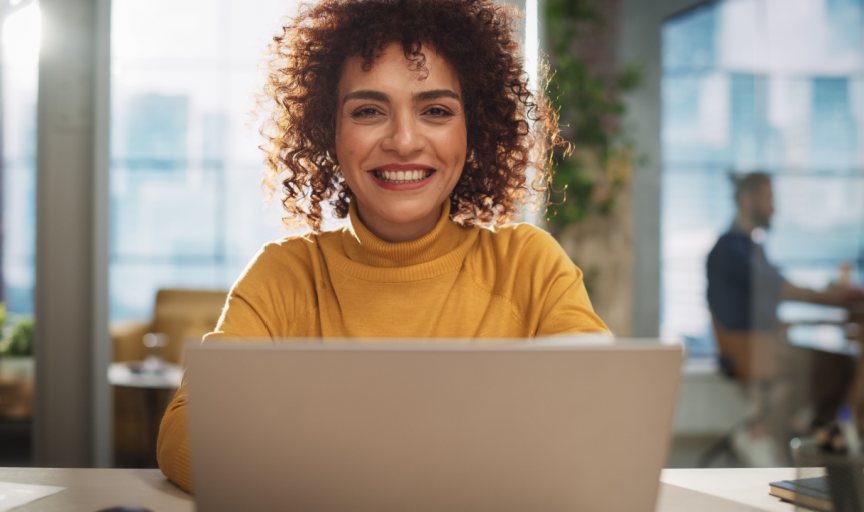 A small business owner sits at her laptop, to illustrate the concept of B2B surveys