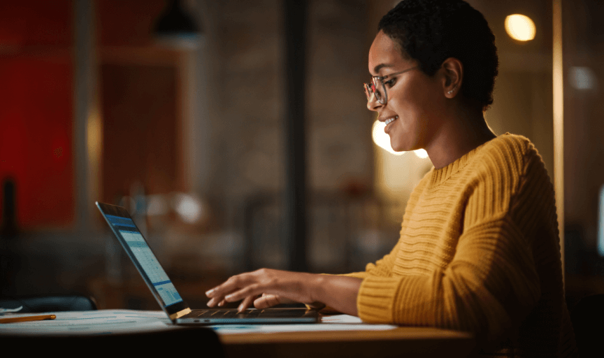 A female employee sits at a laptop providing anonymous feedback via an online survey