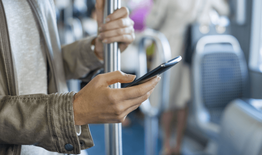 A passenger on a bus completes a non-linear Citizen Engagement survey on her smartphone