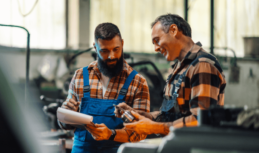 Two workers in an engineering environment discuss ways to enhance their work, to illustrate the concept of improving employee experience