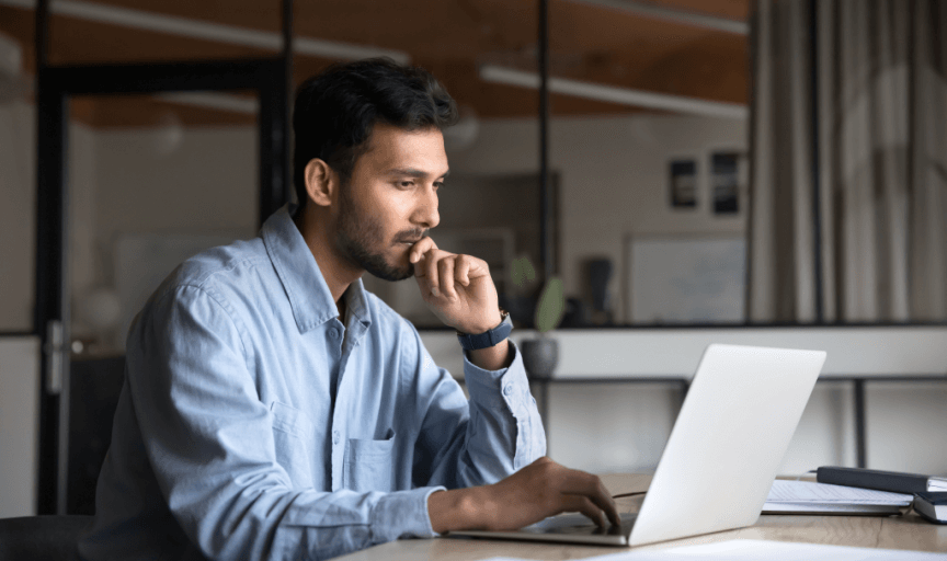 An employee sits at his laptop, providing feedback using an online survey tool
