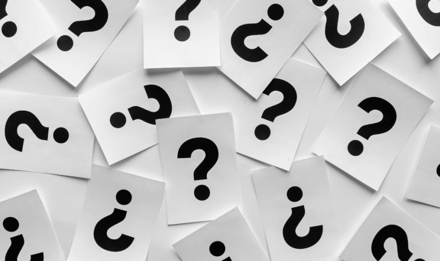 Paper cards, illustrated with black question marks, are scattered randomly over a white background, to represent the variety of survey question examples available to researchers