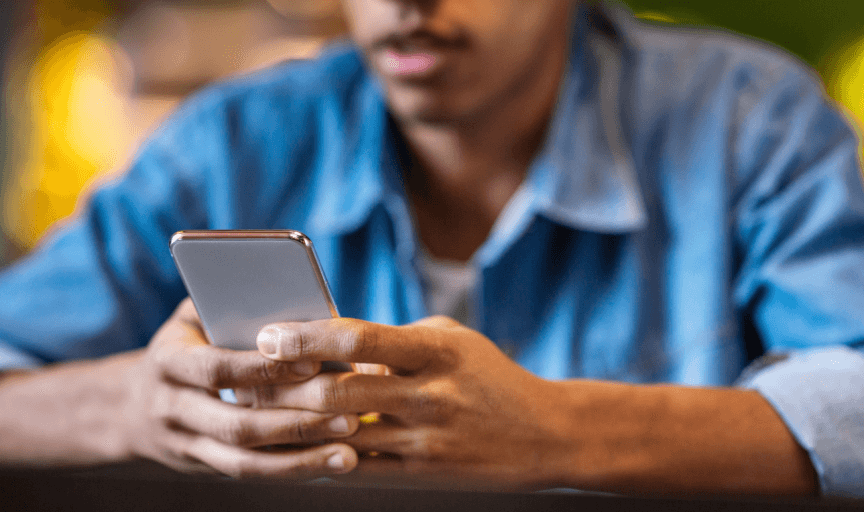 Close up image of a male customer completing a survey on his smartphone