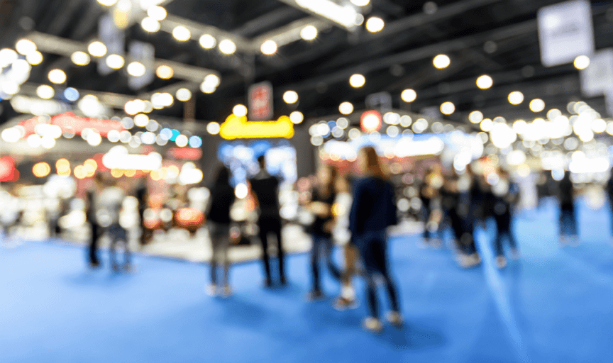 Defocused image of a busy corporate exhibition hall, to illustrate the importance of event metrics when capturing feedback from delegates and exhibitors